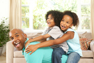 Father Playing With Children At Home